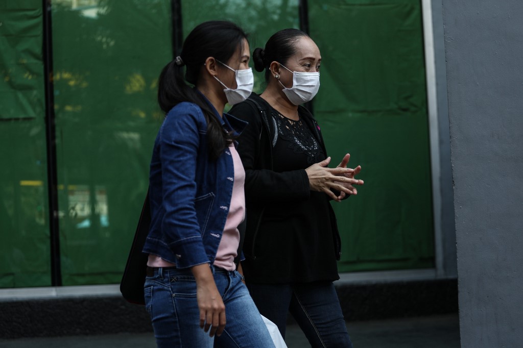 ANXIOUS. Relatives of Filipino crew members stranded on board the coronavirus-stricken Diamond Princess cruise ship, moored off Japan's coast, walk outside a building after meeting with a local employment agency for seafarers in Manila on February 22, 2020. Photo by Basilio H. Sepe/AFP 