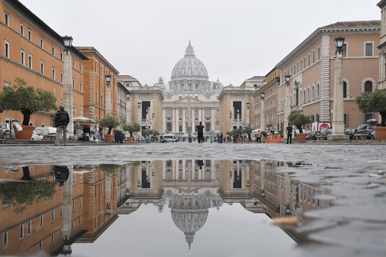VATICAN CITY. St Peter's Basilica reflects in a puddle of Via della Conciliazione on May 9, 2018 in Rome. File photo by Tiziana Fabi/AFP  