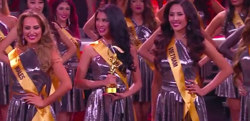 Miss Indonesia holds her Best National Costume award. 