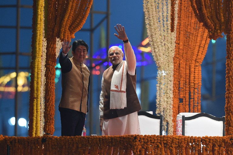 Japan's Prime Minister Shinzo Abe (L) and India's Prime Minister Narendra Modi (R) wave as they attend the evening 'Aarti' ritual on the banks of the River Ganges at Varanasi on December 12, 2015. File photo by Prakash Singh/AFP 