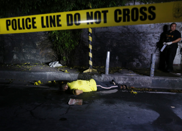 OFF-LIMITS. A Filipino crime scene investigator conducts an investigation where the body of a suspected drug dealer, who was shot dead by an unidentified gunman, lies on a street in Pasay City on August 4, 2016. Photo by Francis Malasig/EPA  