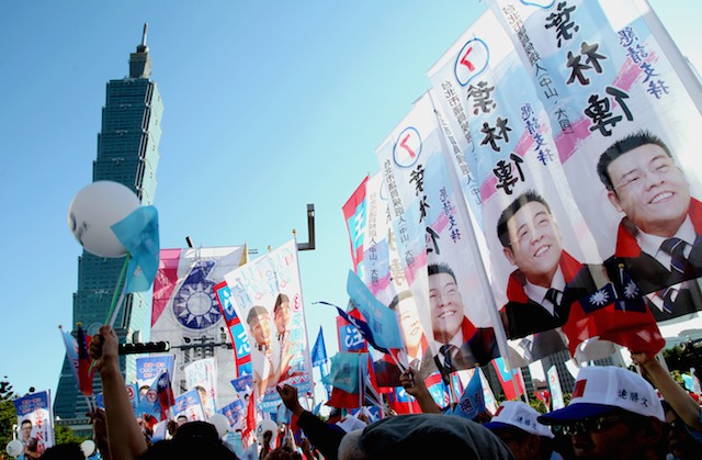 In this file photo, supporters of Taiwan's ruling Chinese Nationalist Party (KMT) wave campaign flags near the Taipei 101 skyscraper at a campaign rally ahead of local elections in Taipei, Taiwan, 22 November 2014. David Chang/EPA