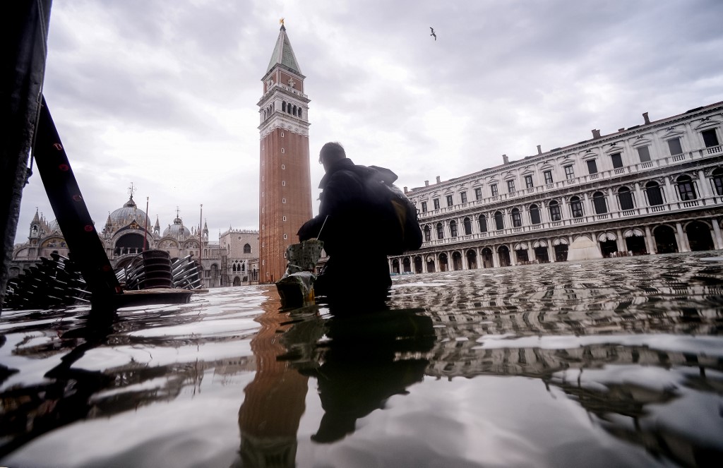 FLOODED. A general view shows a person walking across the flooded St. Mark's Square, with St. Mark's Basilica (Rear L) and the Bell Tower on November 15, 2019 in Venice, two days after the city suffered its highest tide in 50 years. Photo by Filippo Monteforte/AFP 