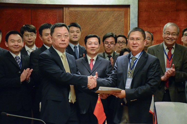 COAST GUARDS. This handout photo taken and released by the Philippine Coast Guard-Public Information Office (PCG-PIO) on December 16, 2016 shows Philippine coast guard commander Commodore Joel Garcia (R) shaking hands with Chinese coast guard deputy director general Yun De (L) at the end of their meeting in Manila. Photo by PCG / AFP 
