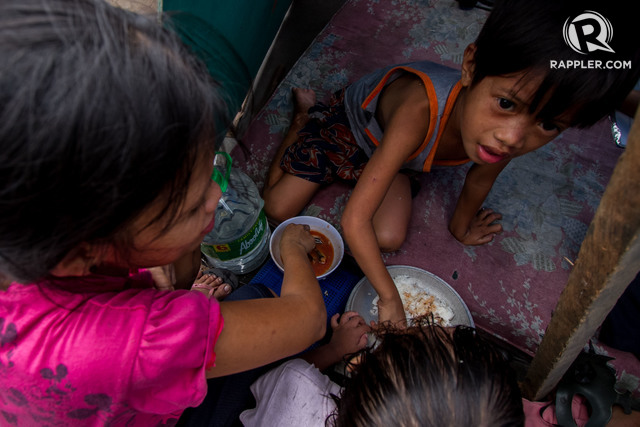 FIGHTING HUNGER. A single can of sardines saves the day of a family in an urban poor community in Quezon City. Photo by Mark Saludes/Rappler  