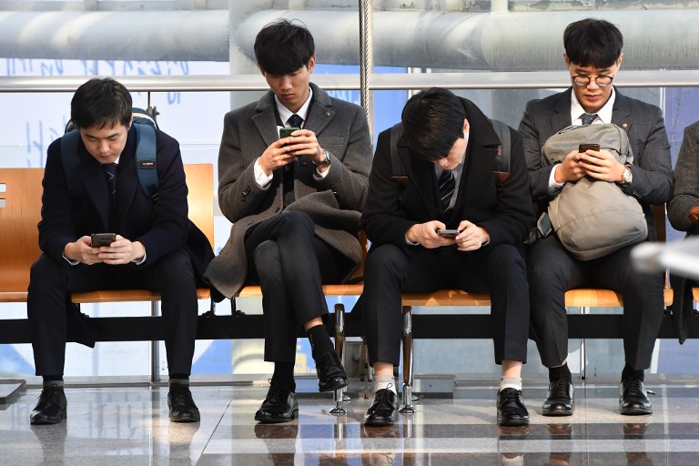 ALL EYES. This picture taken shows job seekers looking at their smartphones while searching for employment during a jobs fair in Seoul. Photo by Jung Yeon-je/AFP 