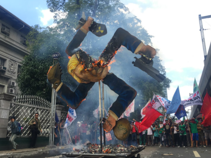 EFFIGY. Protesters burn down the 13-foot tall effigy of US President Donald Trump along Taft Avenue in Manila on the sidelines of the ASEAN Summit. Photo by Raisa Serafica/Rappler 