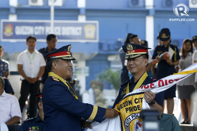 FIRED. In this file photo, Quezon City Police District director PCSupt. Edgardo Tinio (left) accepts the command flag from NCRPO and outgoing QCPD director PCSupt. Joel Pagdilao on July 30, 2015. File photo by Ben Nabong/Rappler 