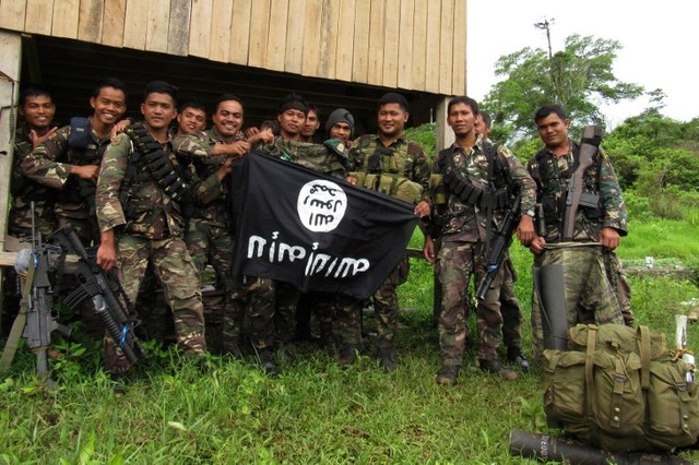 SMALL VICTORY.This photo taken on June 3 shows Philippine soldiers displaying the flag used by the Islamic State group after overrunning a militant camp at a remote village in Butig town, Lanao del Sur province after a 10-day battle. Photo by Richelle Umel/ AFP 