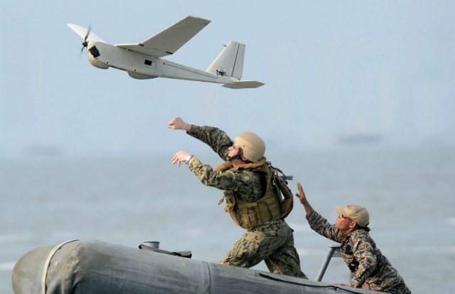 JOINT EXERCISES. US (L) and Philippine (R) navy personnel launch an unmanned aerial vehicle (UAV) from a speedboat off the naval base in Sangley Point, Cavite City, west of Manila on June 28, 2013, as part of the Cooperation Afloat Readiness and Training (CARAT) exercises. File photo by Ted Aljibe/AFP  