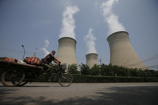 POLLUTED AIR. A man cycles past cooling towers in Beijing, China, 05 August 2013. EPA/Diego Azubel