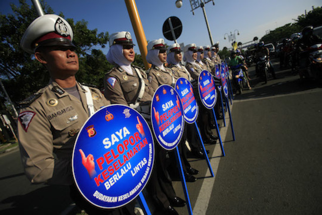 SELAMAT SAMPAI TUJUAN. Anggota Kepolisian RI mempromosikan gerakan Pelopor Keselamatan Lalu Lintas. Foto oleh Hotli Simanjuntak/EPA 