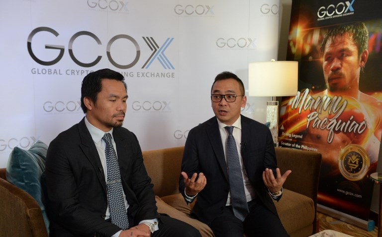 PACQUIAO COIN. Filipino boxing idol Manny Pacquiao (left) listens as Jeffrey Lin, Chief Executive Officer (CEO) of Singapored-based Global Crypto Offering Exchange (GCOX), speaks during an interview with AFP in Manila on April 18, 2018. Photo by Ted Aljibe/AFP 