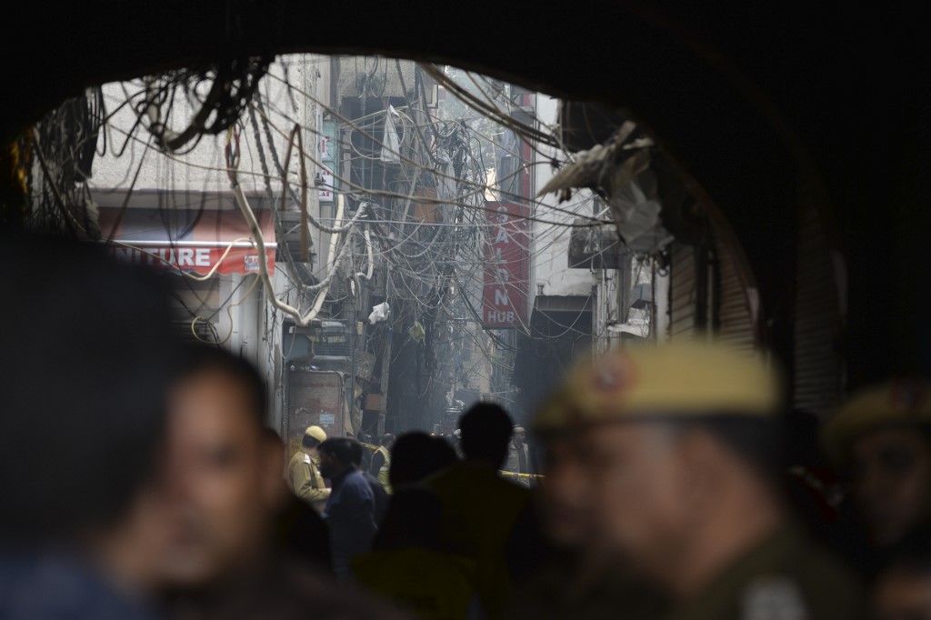 FACTORY FIRE. Police personnel block a street leading to a factory site after a fire broke out, in Anaj Mandi area of New Delhi on December 8, 2019. Photo by Sajjad Hussain/AFP 
