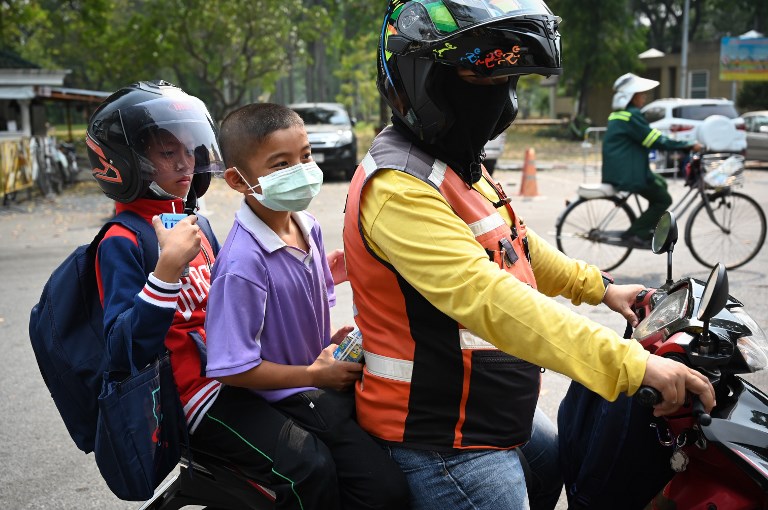 MASKED RIDERS. Children wearing face masks leave school early due to pollution in Bangkok on January 30, 2019. Photo by Lillian Suwanrumpha/AFP 