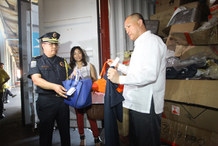 SEIZED. Customs Director Willie Tolentino (left) inspects the seized items with Intellectual Property Office Director Frisco Guce (right). Photo from the Bureau of Customs