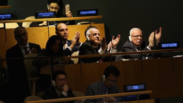 CONDEMNATION. Members of the Palestinian delegation clap after the vote on the floor of the United Nations General Assembly. Photo by AFP 