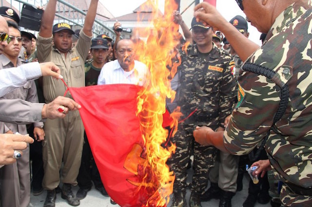 ANTIKOMUNIS. Anggota Banser, organisasi pemuda Nahdlatul Ulama, membakar bendera komunis di Blitar, 30 September 2015. Foto oleh AFP  