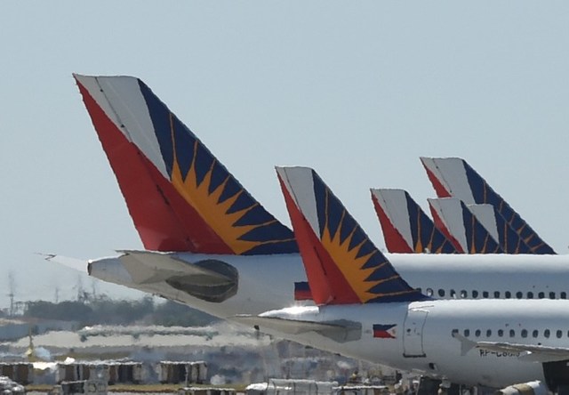 HAZY. This photo taken on January 26, 2016 shows tail sections of Philippine Airlines (PAL) aircraft while parked at the Ninoy Aquino International Airport (NAIA) Terminal 2. File photo by Ted Aljibe/AFP

 