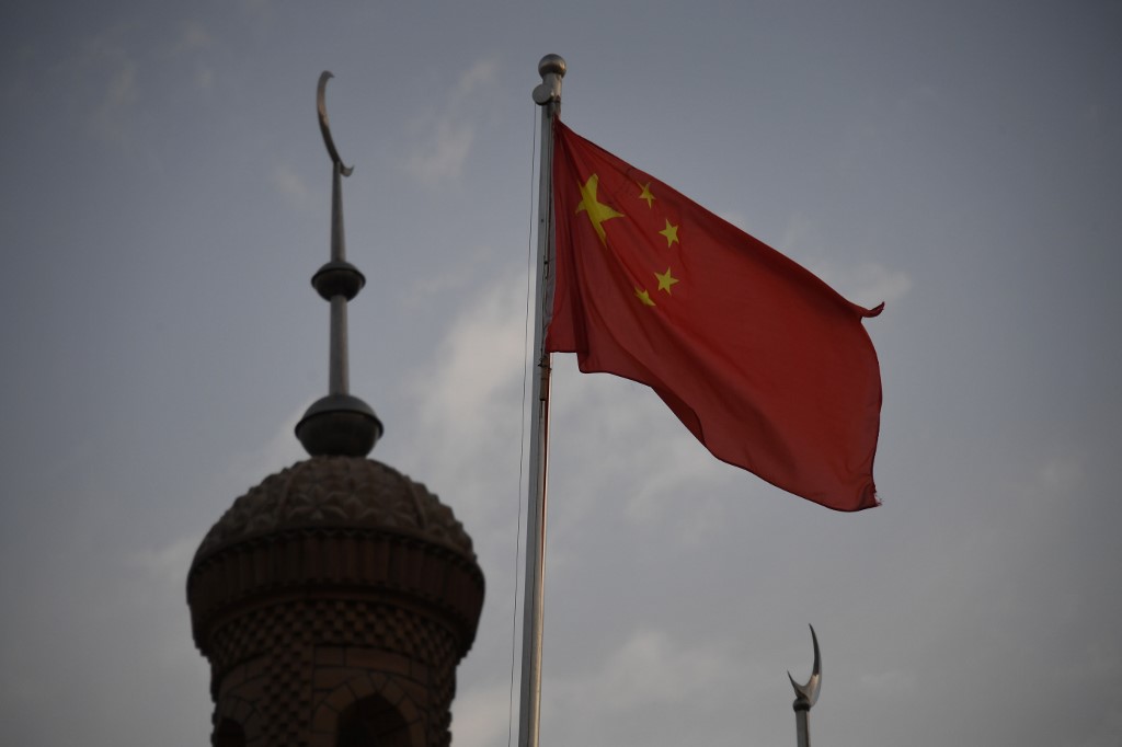 REPRESSION. This photo taken on June 4, 2019 shows the Chinese flag flying over the Juma mosque in the restored old city area of Kashgar, in China's western Xinjiang region. Photo by Greg Baker/AFP 
