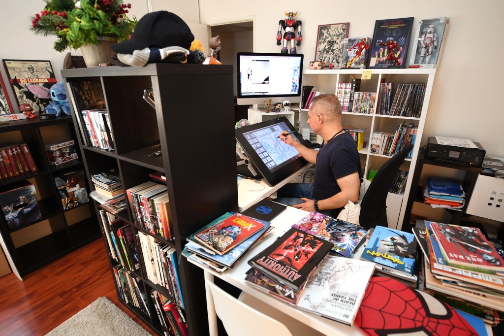 IGNITED. French comic book illustrator Phil Briones works in his home office in Los Angeles. Photo by Robyn Beck / AFP 