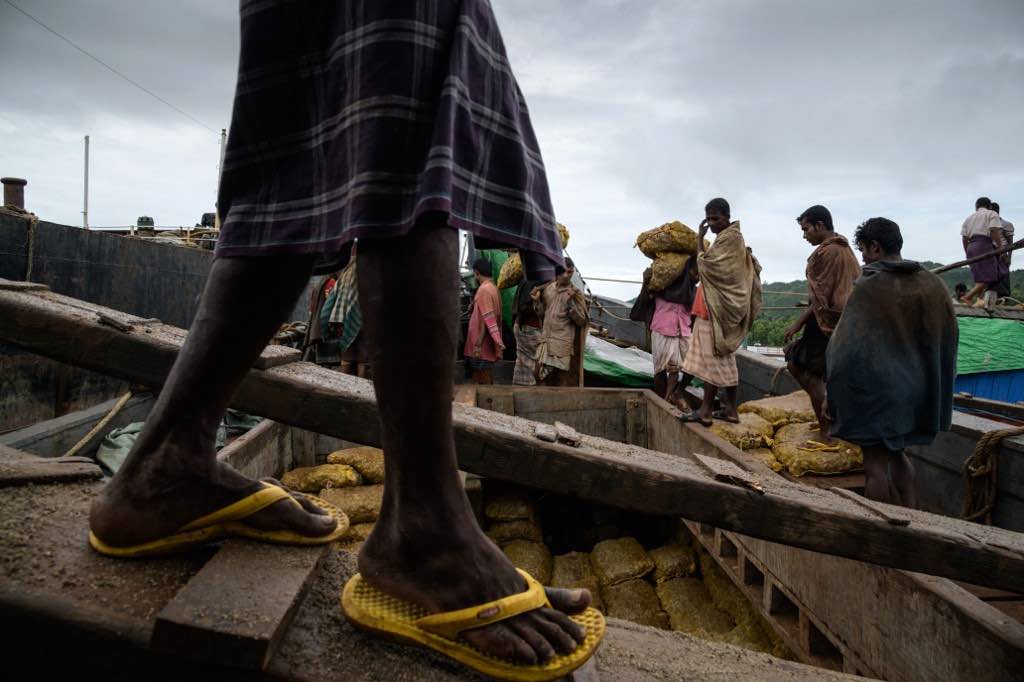ROHINGYA. In this photo taken on August 13, 2018, Rohingya workers transport sacks of ginger from a boat, which arrived from Myanmar's Rakhine state, to waiting trucks at Teknaf port near Cox's Bazar. Photo by Ed Jones / AFP 