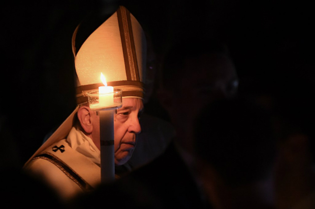 EASTER VIGIL. Pope Francis holds an altar candle as he arrives to preside over the Easter Vigil on April 20, 2019 at St. Peter's Basilica in the Vatican. Photo by Vincenzo Pinto/AFP 