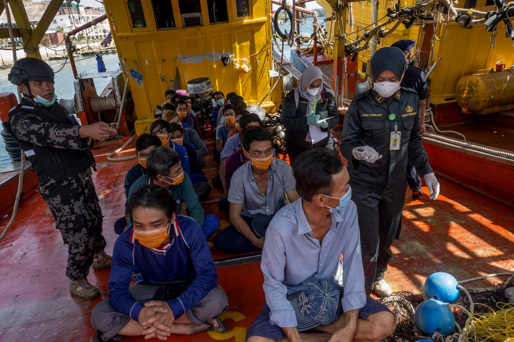 DETAINED. This picture taken in Batam, Kepulauan Riau on March 4, 2020 shows Indonesian officials standing next to Vietnamese fishermen detained by Indonesian authority for illegal fishing in Natuna water. Photo by Teguh Prihatna/AFP 
