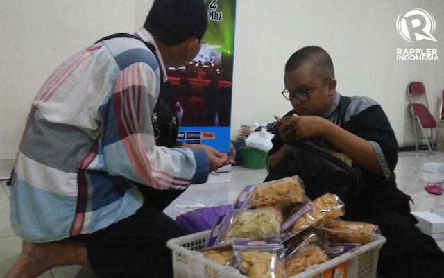 MAKANAN RINGAN. Muhammad Akbar Satriawan (berkacamata), penyandang difabel netra sedang melayani pembeli makanan ringan. Foto oleh Anang Zakaria/Rappler  