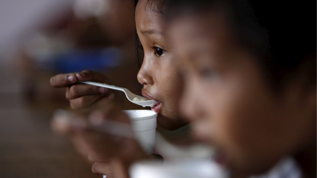 EASING HUNGER. Filipino children eat their meals during a feeding program initiated by a child advocates group to fight malnutrion and hunger. File photo by Dennis Sabangan/EPA