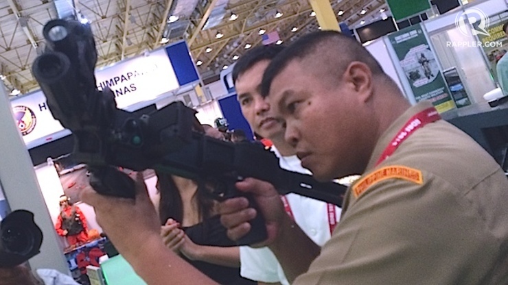 POPULAR BOOTH: A Filipino soldier tries the CornerShot weapon accessory at the ADAS 2014 defense and security exhibit in Manila. Rappler photo 