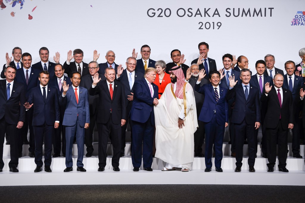 NOT LISTENING. US President Donald Trump shakes hands with Saudi Arabia's Crown Prince Mohammed bin Salman as leaders pose for a family photo at the G20 Summit in Osaka on June 28, 2019. Photo by Brendan Smialowski/AFP  