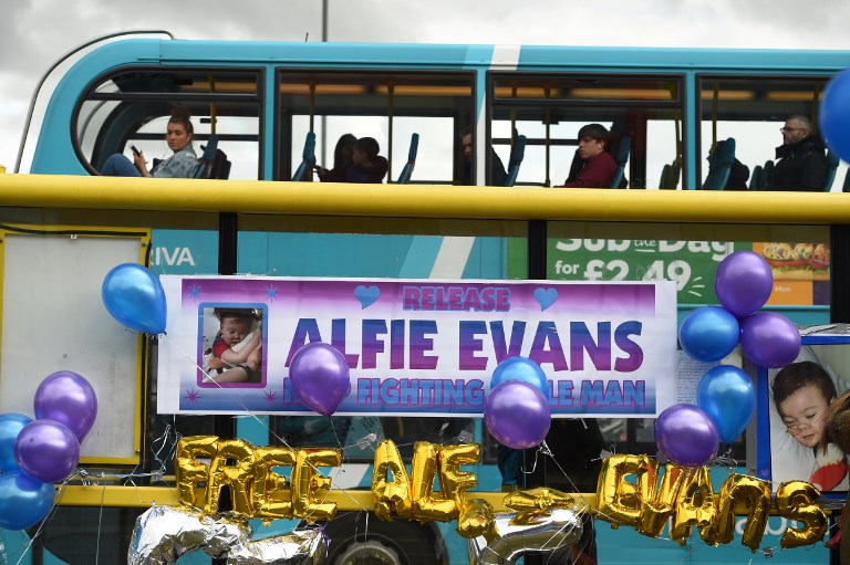 ALFIE EVANS. A bus passes balloons and posters left in support of British toddler Alfie Evans, on a bus-stop opposite Alder Hey childrens hospital in Liverpool, north-west England on April 26, 2018. Alfie Evans, who is 22 months old, has a rare degenerative neurological condition which has not been definitively diagnosed. Photo by Oli Scarff/AFP 