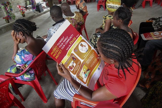 A Liberian woman reads an Ebola information poster on the prevention of the Ebola epidemic, during UNICEF's sensitization campaign at the Mission for Today Holy Church, in Newkru Town, Monrovia, Liberia, 22 June 2014. Ahmed Jallanzo/EPA