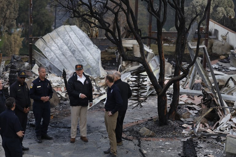 IN RUINS. President Donald Trump (C) surveys the damage from the Woolsey fire in Malibu on November 17, 2018. Photo by Genaro Molina/POOL/AFP 