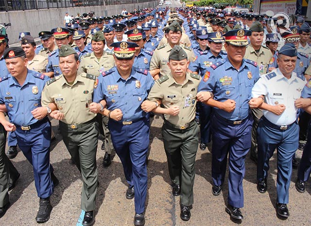 'SHOW OF UNITY.' Philippine National Police and Armed Forces of the Philippines officers and members link arms in a Unity Walk along EDSA to the People Power Monument during the 29th People Power Anniversary Celebration on Feb 25, 2015. Photo by Joel Leporada/Rappler   