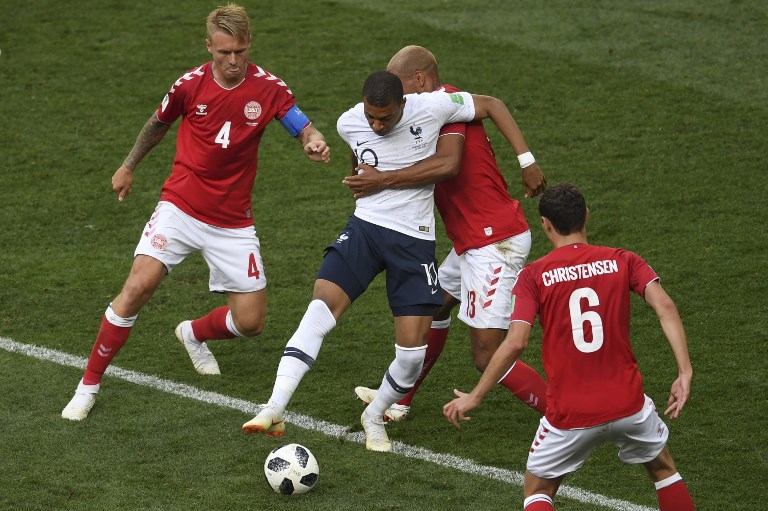DEADLOCK. France's forward Kylian Mbappe (center) controls the ball as he is marked by Denmark's defender Mathias Jorgensen in their Group C match. Photo by Yuri Cortez/AFP  