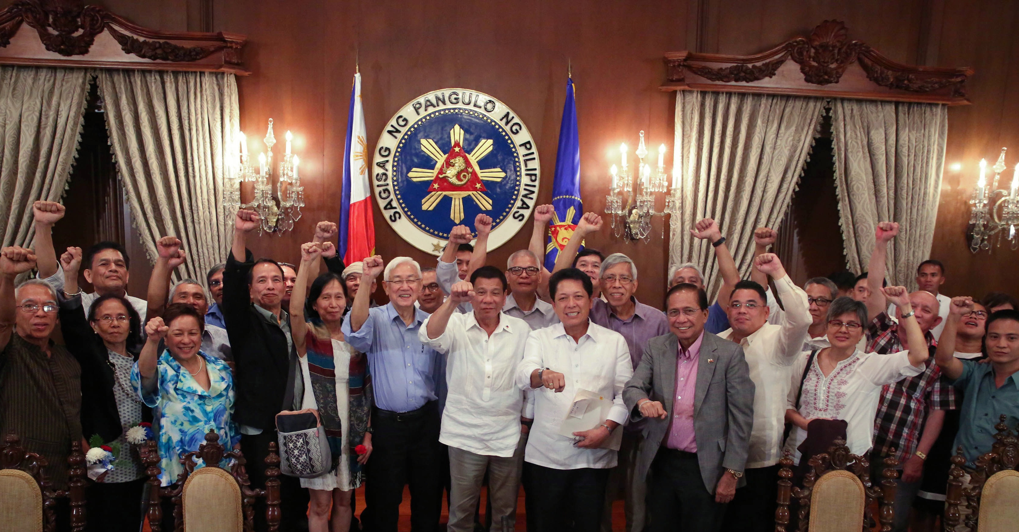CLENCHED FISTS. President Rodrigo Duterte joins communist rebels in their signature gesture – the raised clenched fist. He has a similar gesture – a fist bump – that has become both popular and notorious worldwide. Malacañang photo  