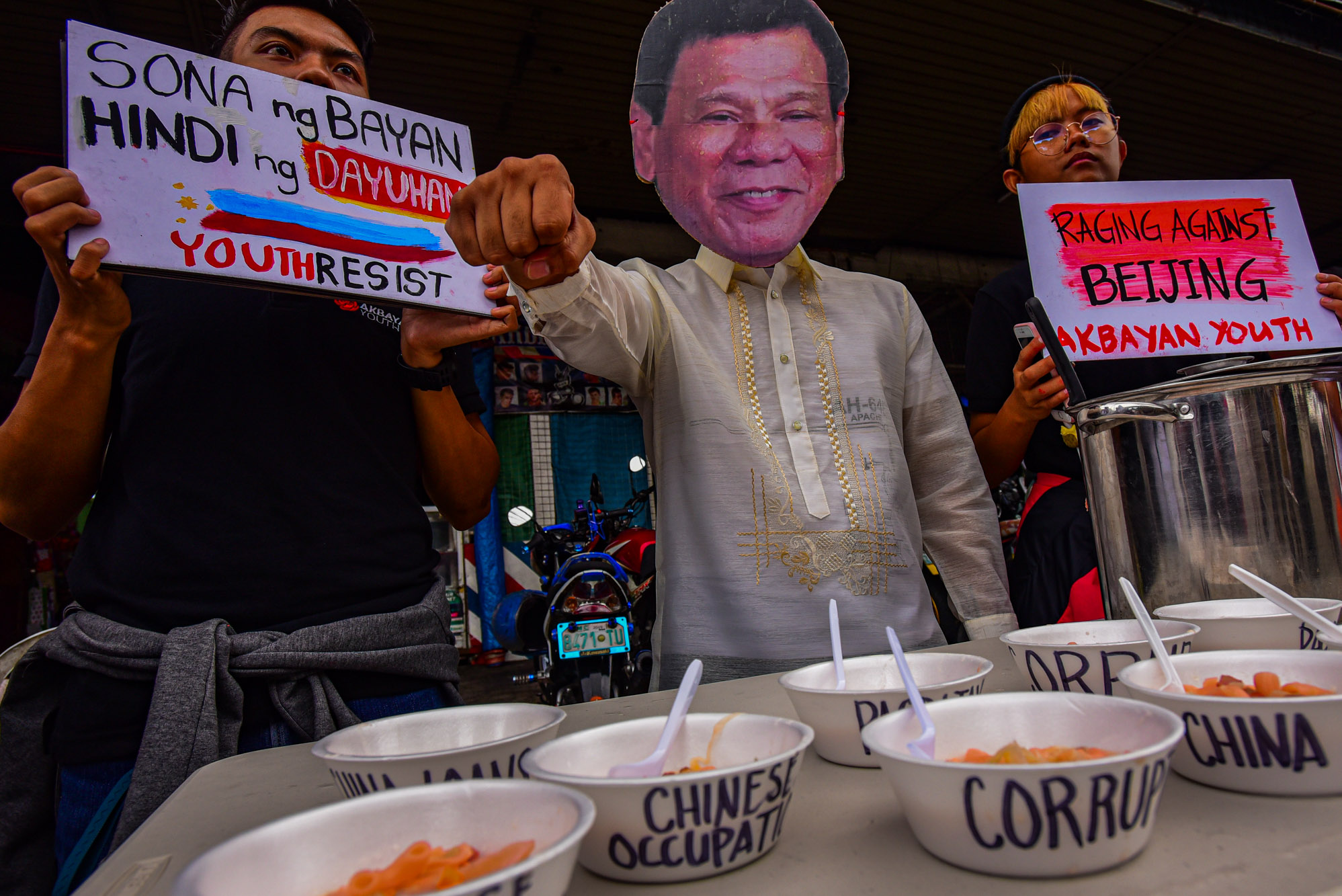 PRIORITIES. In an alternative SONA activity called SOPAS: State of the Province of China Address, a man wearing a Duterte mask gives out soup bowls labeled with Duterte's failed promises and twisted priorities. Photo by Maria Tan/Rappler