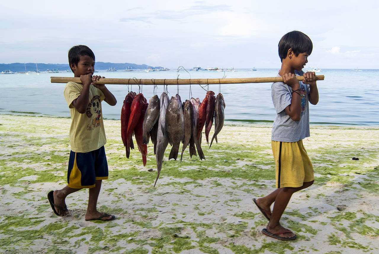 BORACAY CLOSURE. Children carry fresh catch across Boracay beach a few weeks before the island closed temporarily for rehabilitation. Photo by Angie de Silva/Rappler 