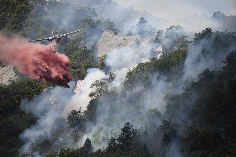 FOREST FIRE. A plane drops flame retardant to put out a fire in Rigaud, north of Nice, France on August 3, 2017. Photo by Yann Coatsaliou/AFP  
