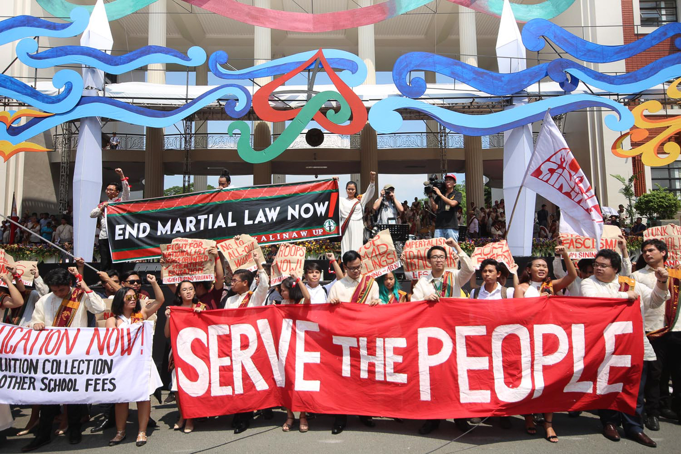 SERVE THE PEOPLE. Activists, students, and graduates hold a protest during UP Diliman's 106th graduation rites on June 25, 2017. Photo by Darren Langit/Rappler