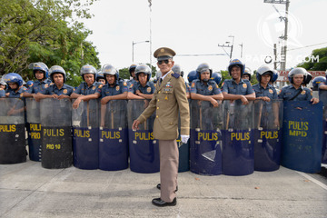 LOYALIST. A Marcos loyalist claiming to be a war veteran walks past a police barricade blocking the entrance of the Libingan ng mga Bayani