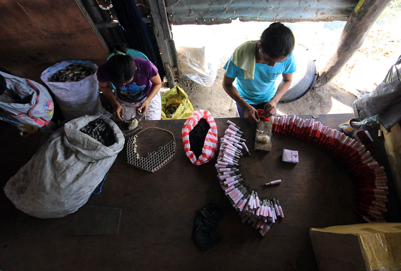 NEW YEAR'S EVE PREPS. Firecrackers and luces workers load a powder or polvora inside luces shells at a fireworks factory in Bocaue, Bulacan on December 26, 2017. Photo by Darren Langit/Rappler  
