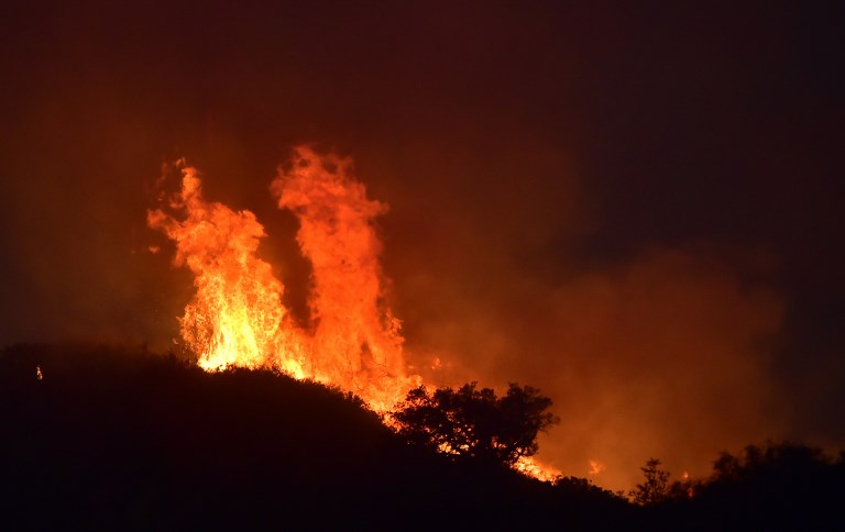STILL ABLAZE. Fire rages along Romero Canypn hillsides in Montecito, north of Santa Barbara, California on December 12, 2017. File photo by Frederick J. Brown/AFP  