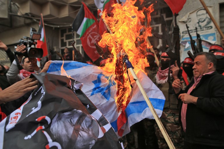 ANGER IN GAZA. Palestinian protestors burn the Israeli flag and a poster of US President Donald Trump following his decision to recognize Jerusalem as the capital of Israel, in Gaza City, on December 7, 2017. Mohammed Abed/AFP 
