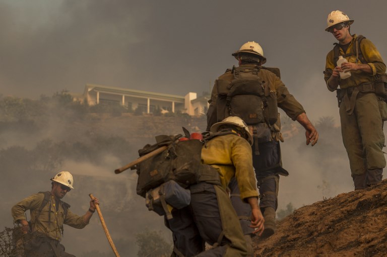FIRE FIGHTING. A Hot Shot crew climbs a hill while cutting a line among homes at the Thomas Fire on December 16, 2017 in Montecito, California. David McNew/Getty Images/AFP 