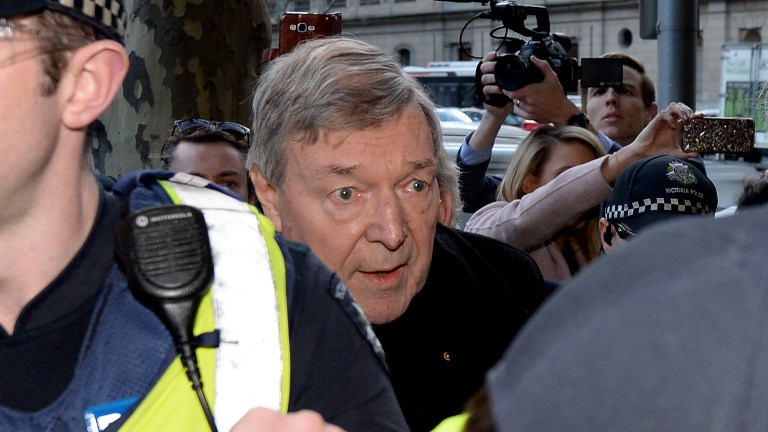Vatican finance chief Cardinal George Pell (C) arrives under heavy police protection for a hearing at the Melbourne Magistrates Court in Melbourne on July 26, 2017. Mal Fairclough/AFP 