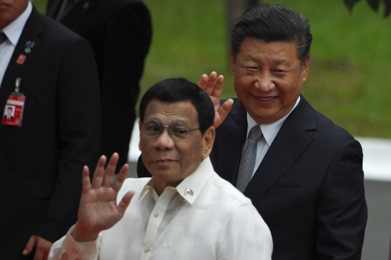HEADS OF STATE. Chinese President Xi Jinping and Philippine President Rodrigo Duterte wave to members of the media after inspecting the honor guard during a welcoming ceremony in Malacañang on November 20, 2018. Photo by Ted Aljibe/AFP     
