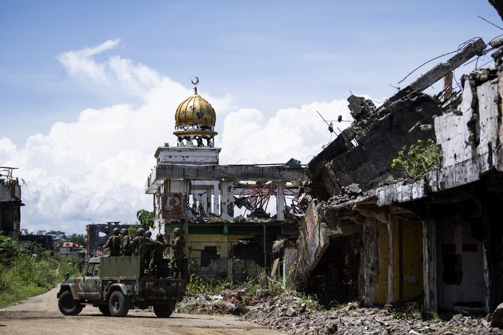 STILL IN RUINS. A band of soldiers ride by the ruins of a mosque in Marawi City, where the May 2017 siege by ISIS-linked terrorists prompted President Rodrigo Duterte to place all of Mindanao under martial law. Photo by Noel Celis/Agence France-Presse 